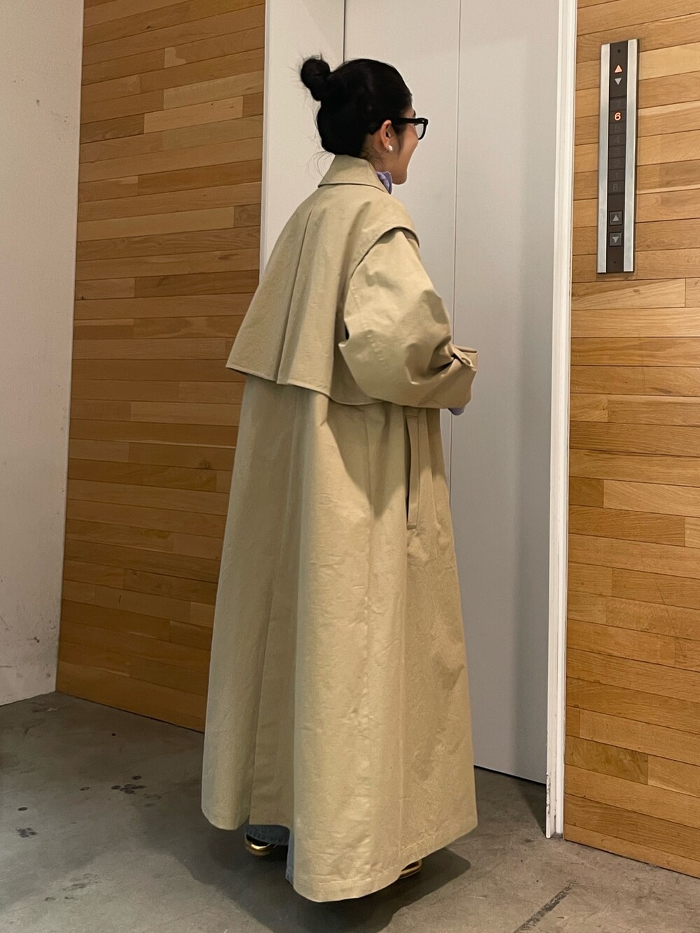 ブルー系のデニムパンツ、ベージュ系のその他アウター、パープル系のTシャツ/カットソーを着用したレディースの冬コーディネートの3枚目の写真