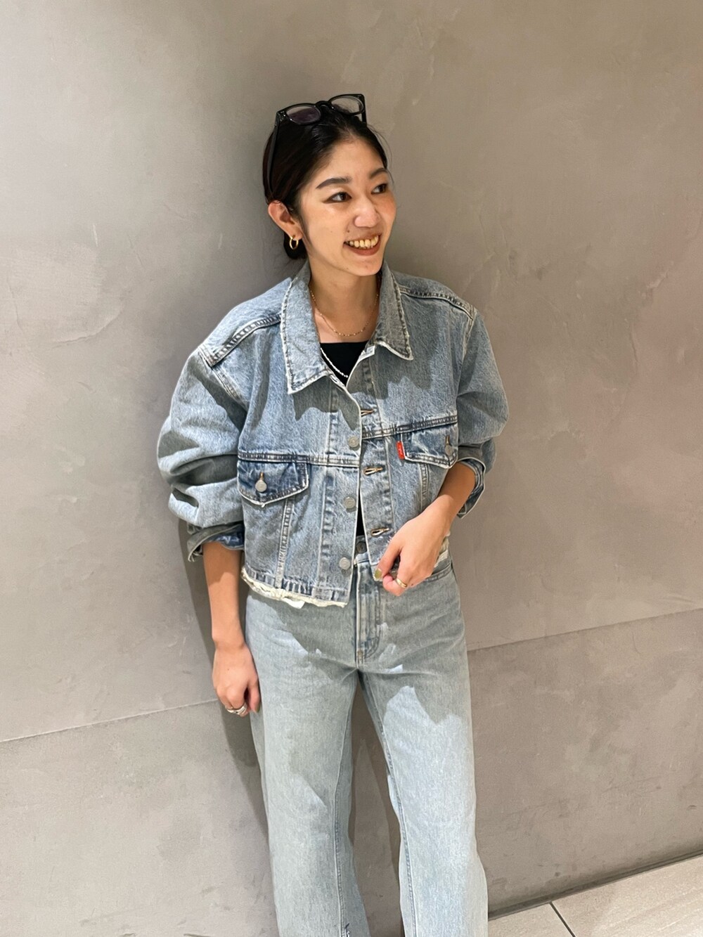 ブルー系のデニムジャケット、ブルー系のデニムパンツ、シルバー系のパンプスを着用したレディースの夏コーディネートの4枚目の写真