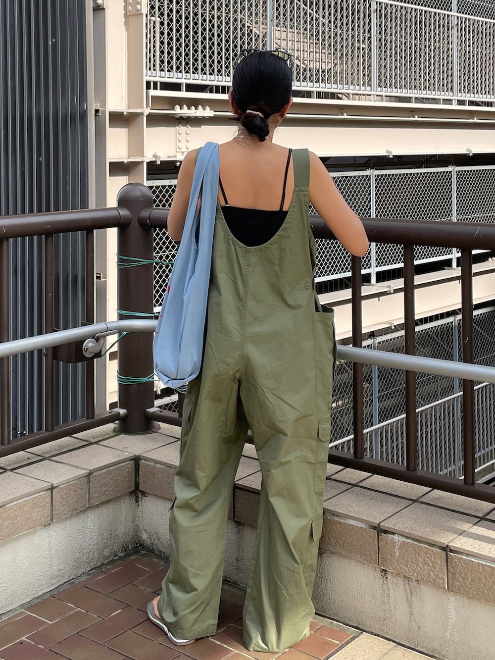 グリーン系のサロペット/オーバーオール、ブルー系のエコバッグ/サブバッグ、ブラック系のキャミソールを着用したレディースの夏コーディネートの3枚目の写真