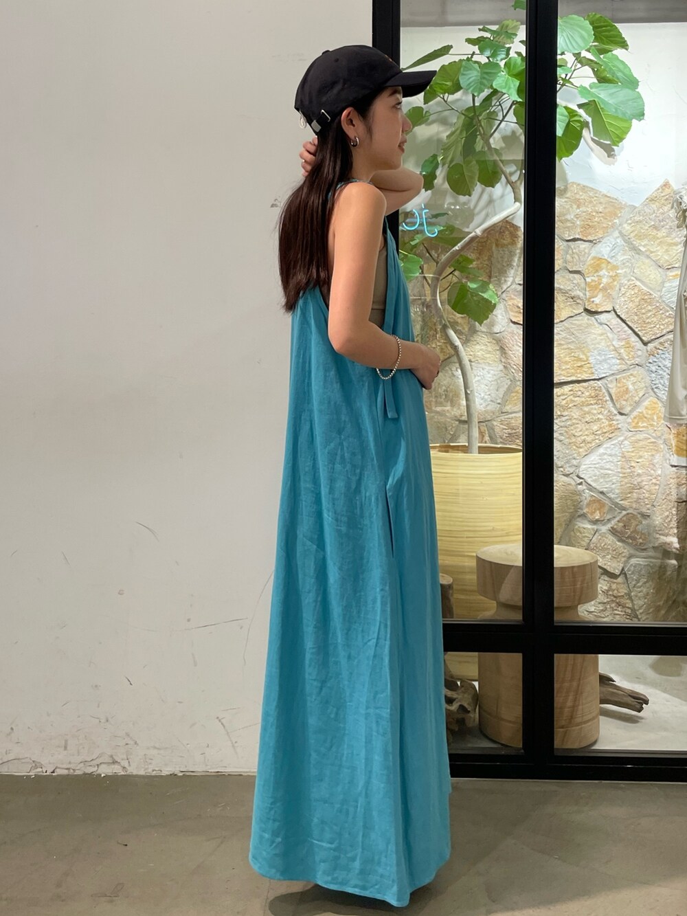 ブルー系のワンピース、グレー系のキャミソール、グレー系のキャップを着用したレディースの夏コーディネートの2枚目の写真