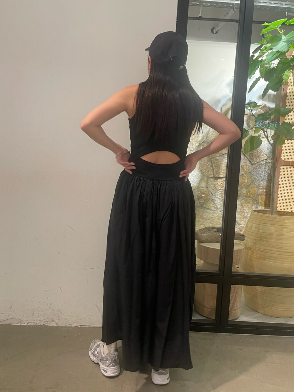 ブラック系のワンピース、グレー系のキャップを着用したレディースの春コーディネートの5枚目の写真