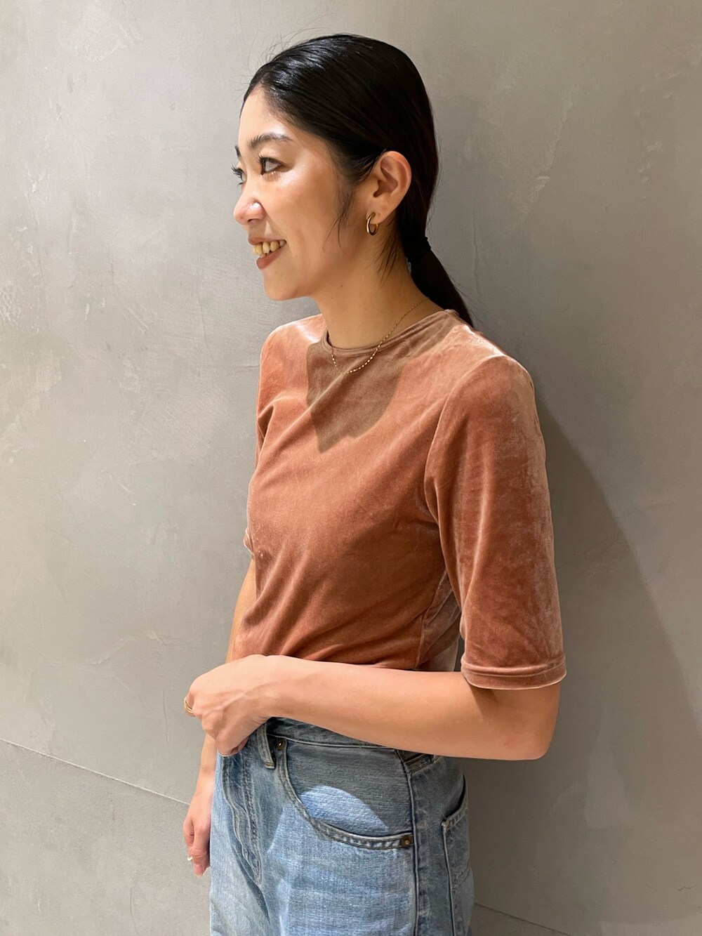 ブルー系のデニムパンツ、シルバー系のパンプス、オレンジ系のTシャツ/カットソーを着用したレディースの秋コーディネートの3枚目の写真