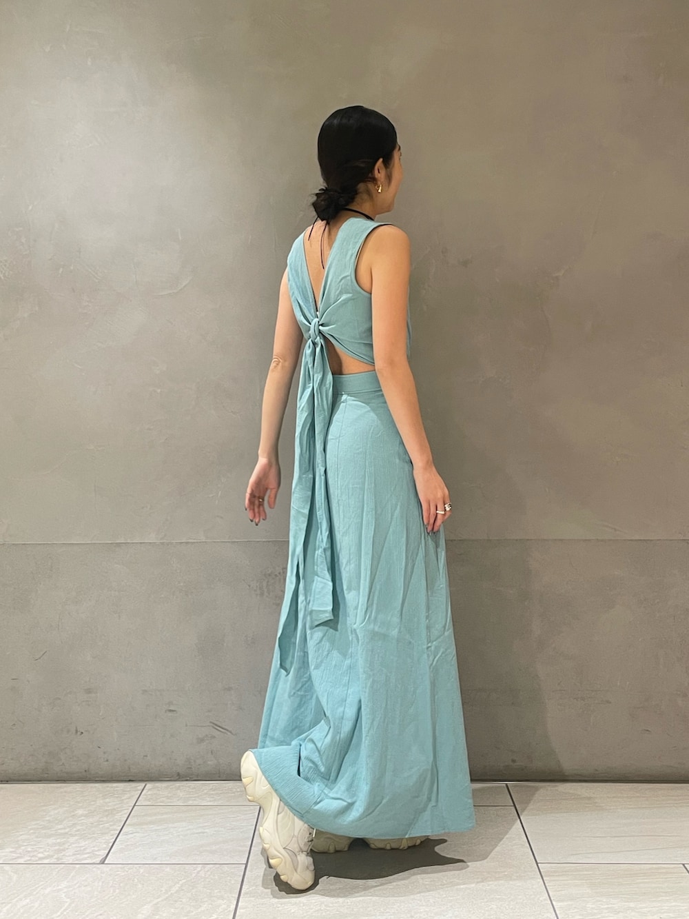 ブルー系のワンピース、ゴールド系のネックレスを着用したレディースの春コーディネートの2枚目の写真