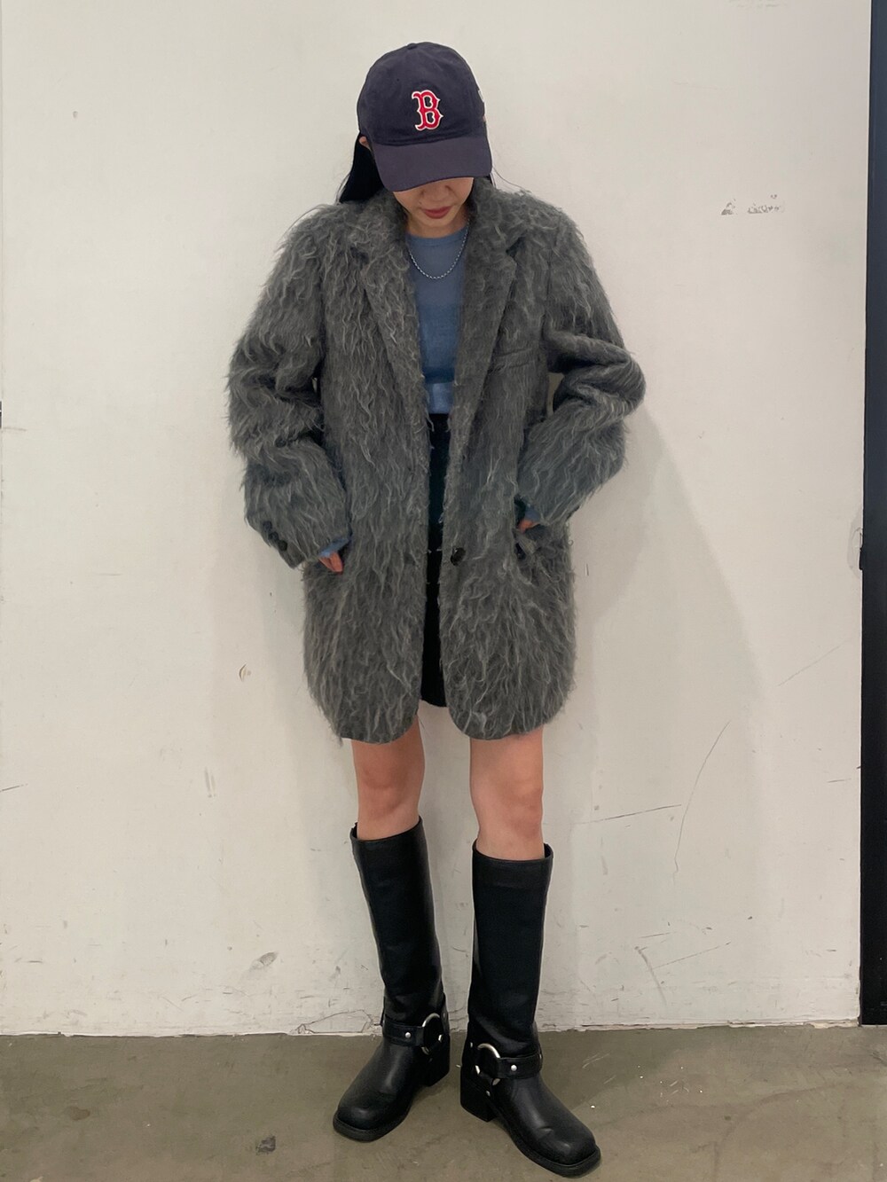 グレー系のテーラードジャケット、ブラック系のブーツ、グレー系のスカートを着用したレディースの秋コーディネートの6枚目の写真