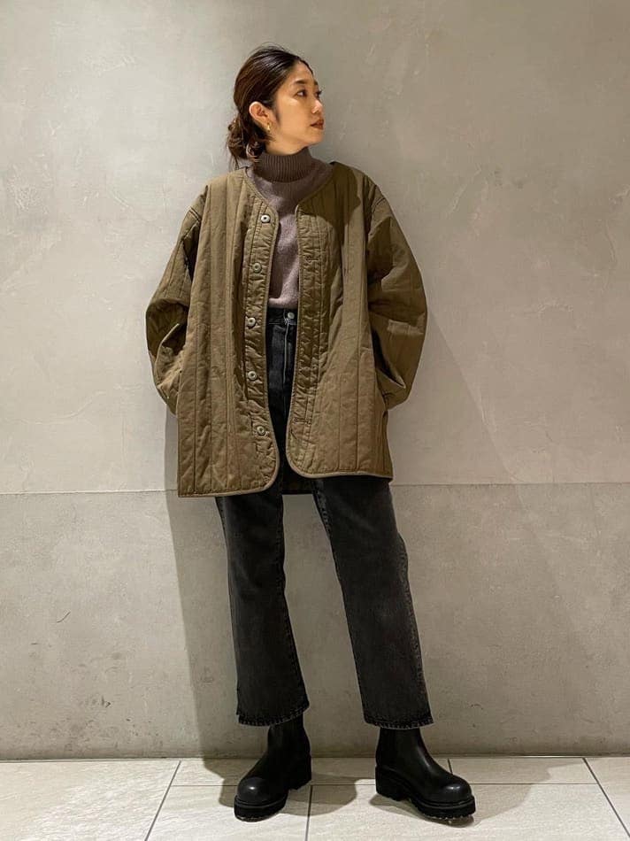 ブラック系のデニムパンツ、ベージュ系のその他アウター、ブラック系のブーツを着用したレディースの秋コーディネートの2枚目の写真