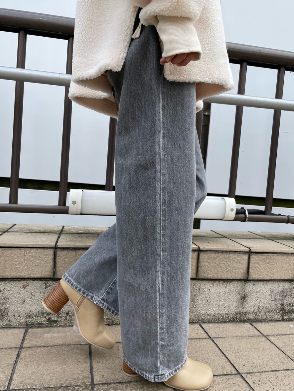 ホワイト系のTシャツ/カットソー、ブラック系のデニムパンツ、ベージュ系のブーツを着用したレディースの秋コーディネートの7枚目の写真