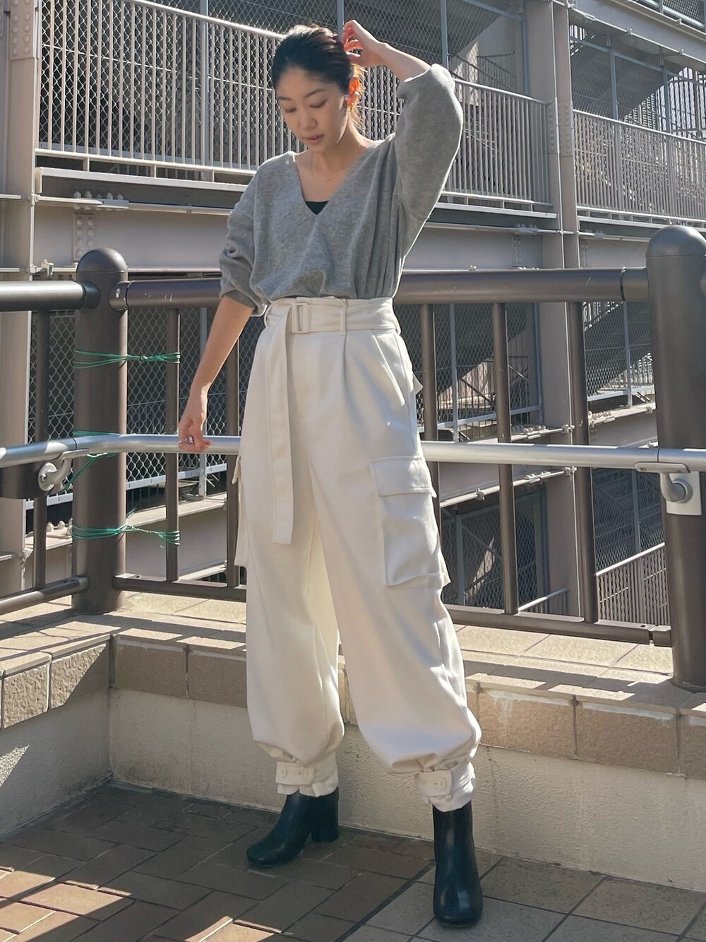 レッド系のニット/セーター、ホワイト系のカーゴパンツを着用したレディースの冬コーディネートの4枚目の写真