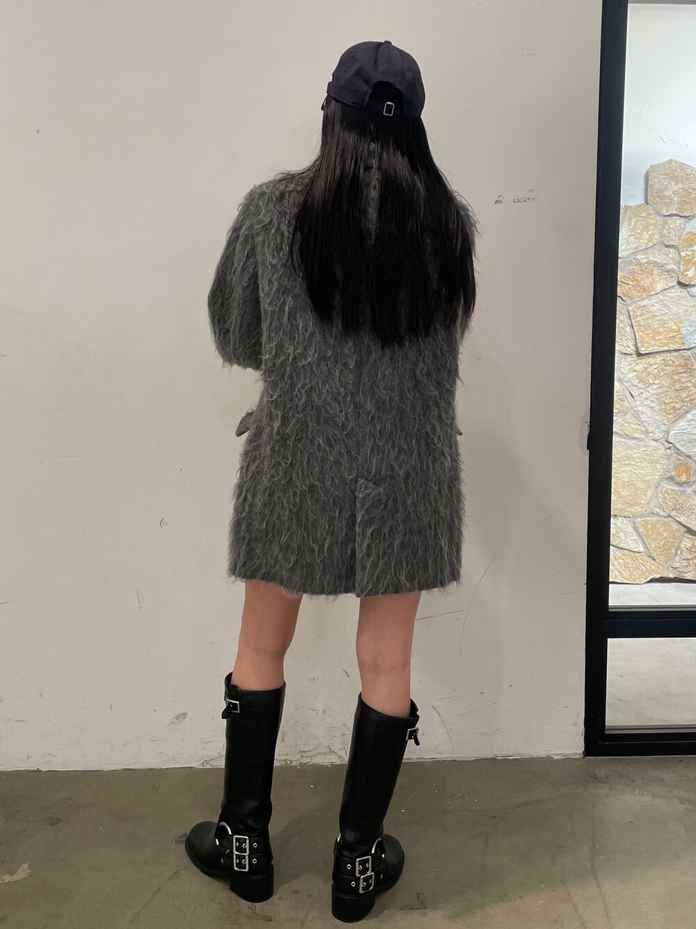 グレー系のテーラードジャケット、ブラック系のブーツ、グレー系のスカートを着用したレディースの秋コーディネートの5枚目の写真