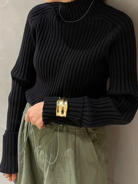 ブラック系のチェスターコート、ベージュ系のその他パンツ、ブラック系のニット/セーターを着用したレディースの秋コーディネートの3枚目の写真