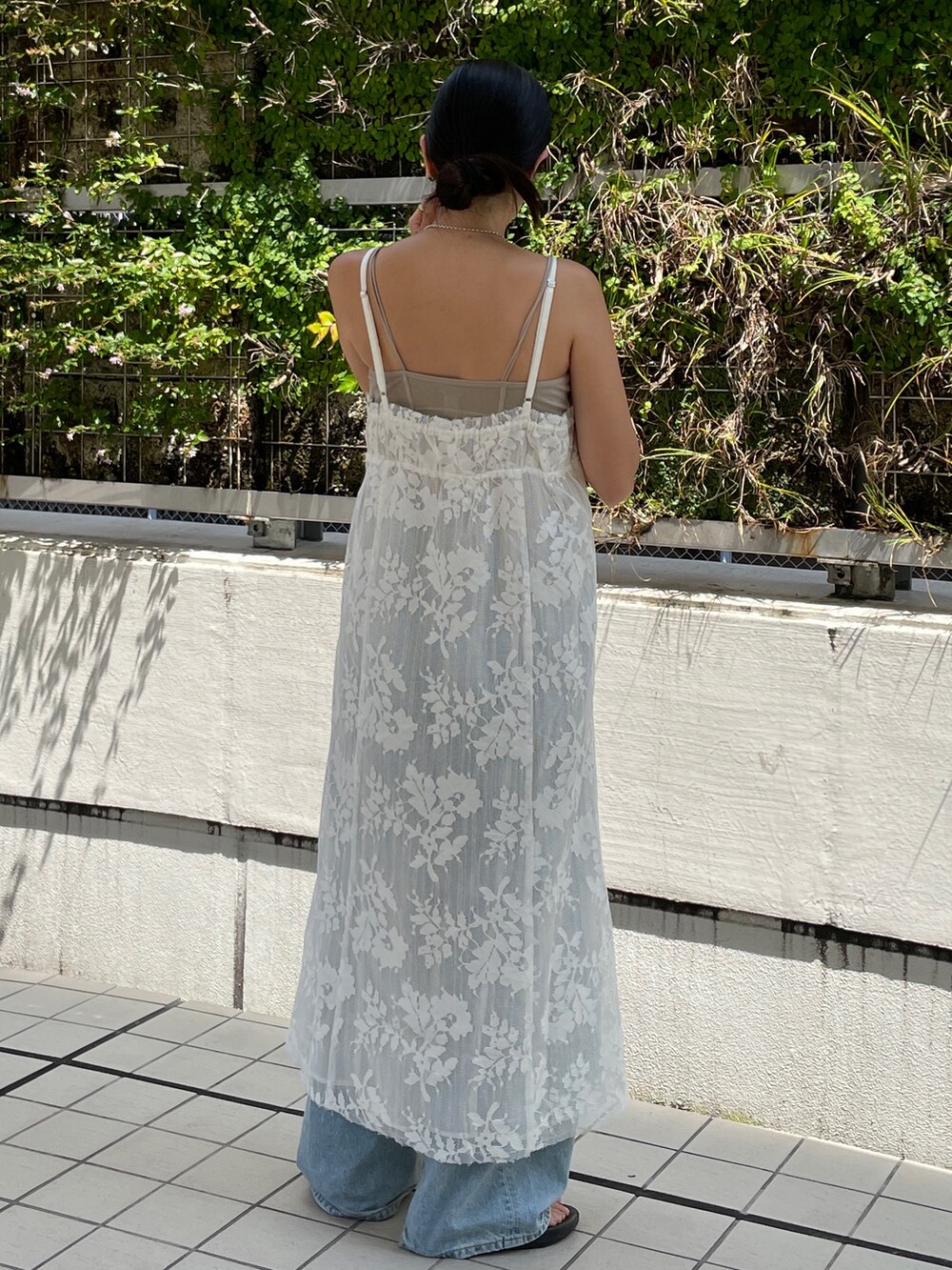 ホワイト系のワンピース、グレー系のキャミソール、ブルー系のデニムパンツを着用したレディースの夏コーディネートの2枚目の写真