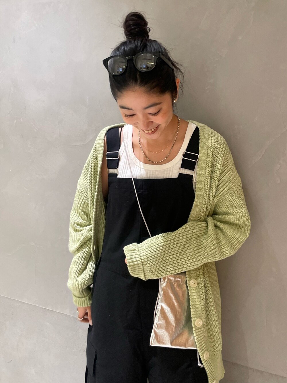 ブラック系のつなぎ/オールインワン、ホワイト系のタンクトップ、グリーン系のカーディガン/ボレロを着用したレディースの冬コーディネートの3枚目の写真