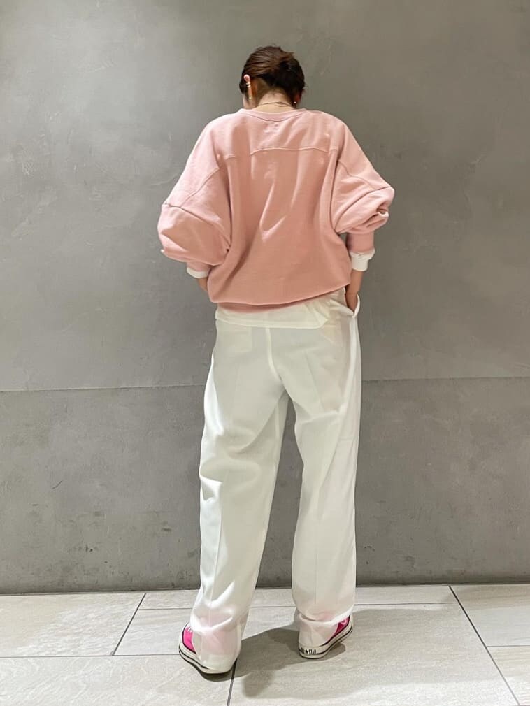 ホワイト系のスラックス、ピンク系のスウェット、ピンク系のスニーカーを着用したレディースの冬コーディネートの6枚目の写真
