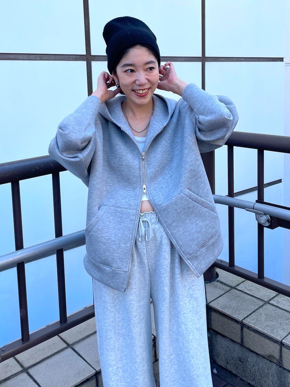 ブラック系のブルゾン、グレー系のパーカー、グレー系のスウェットパンツを着用したレディースの秋コーディネートの6枚目の写真