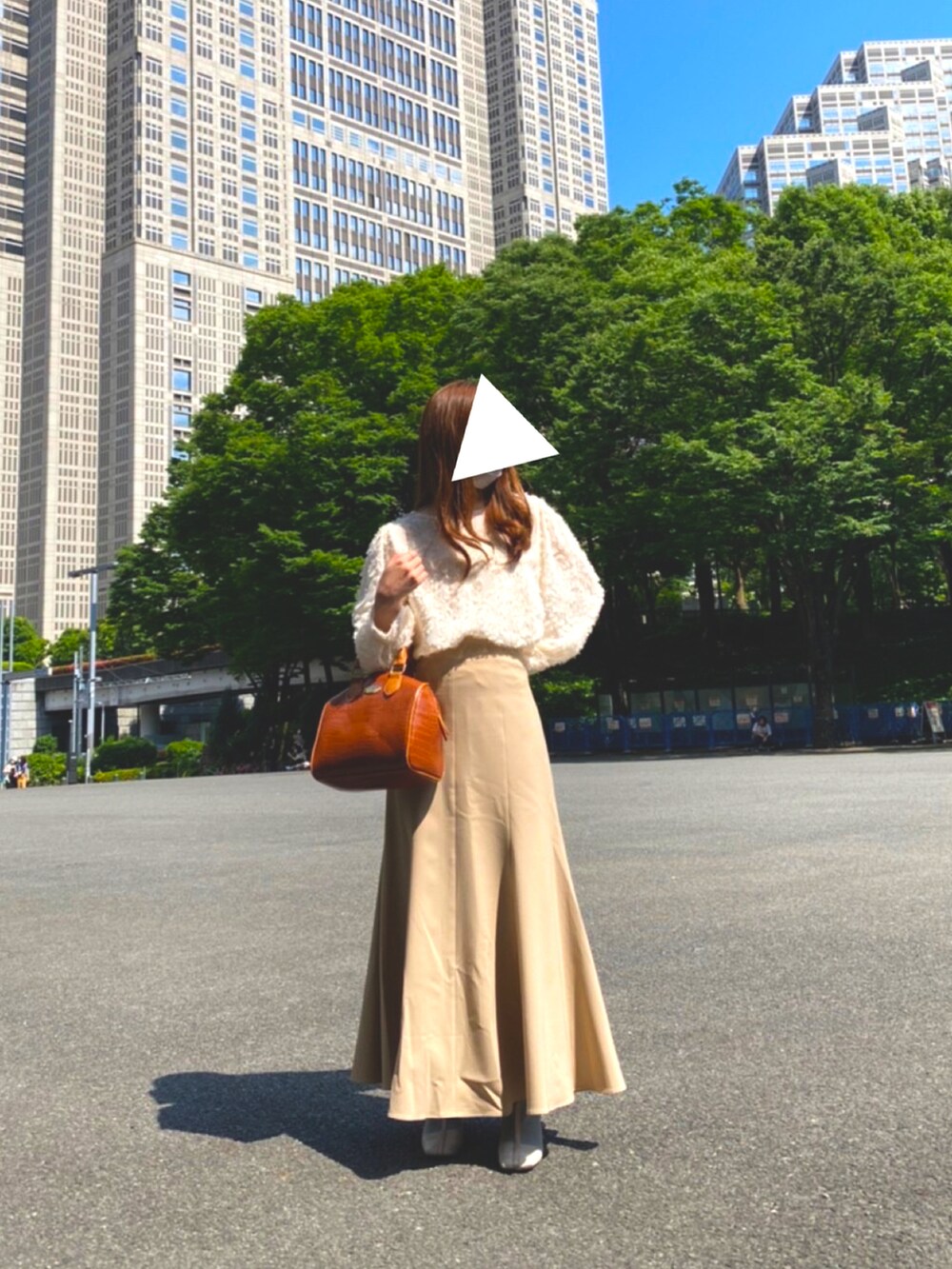 ベージュ系のスカート、ホワイト系のシャツ/ブラウス、ブラウン系のボストンバッグを着用したレディースの夏コーディネートの2枚目の写真