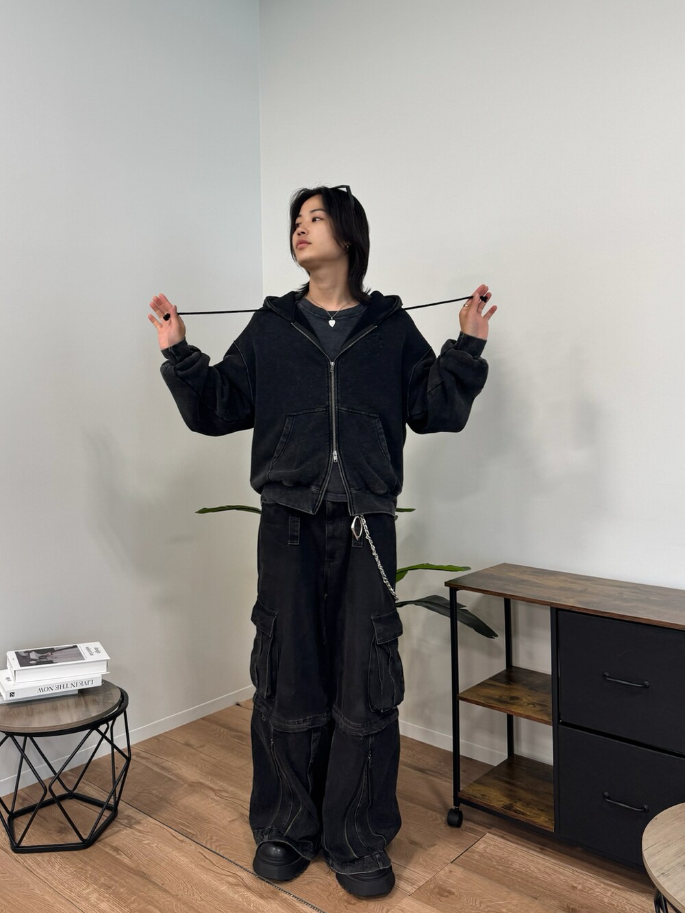 ブラック系のパーカー、ブラック系のカーゴパンツを着用したメンズの秋コーディネートの3枚目の写真