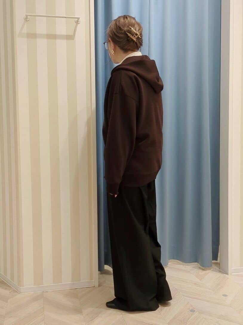ブラウン系のパーカー、ブラック系のその他パンツを着用したレディースの冬コーディネートの2枚目の写真