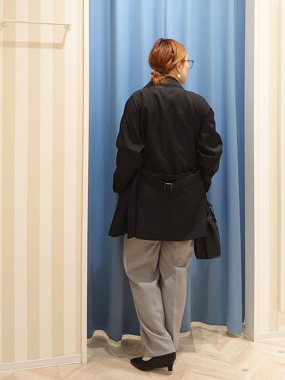 ブラック系のトレンチコート、ホワイト系のシャツ/ブラウス、グレー系のその他パンツを着用したレディースの冬コーディネートの3枚目の写真