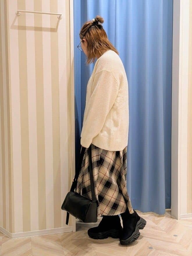 ホワイト系のニット/セーター、ベージュ系のスカート、ブラック系のショルダーバッグを着用したレディースの冬コーディネートの2枚目の写真