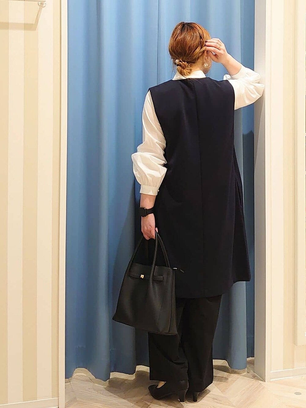 ブルー系のベスト、ホワイト系のシャツ/ブラウス、ブラック系のその他パンツを着用したレディースの冬コーディネートの3枚目の写真