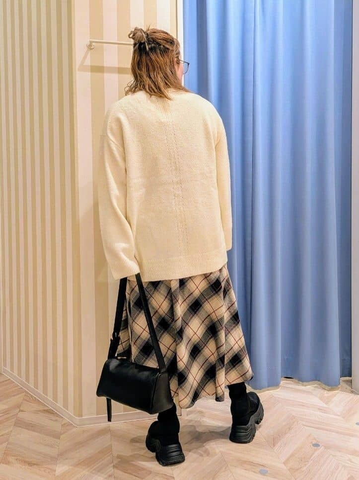 ホワイト系のニット/セーター、ベージュ系のスカート、ブラック系のショルダーバッグを着用したレディースの冬コーディネートの3枚目の写真