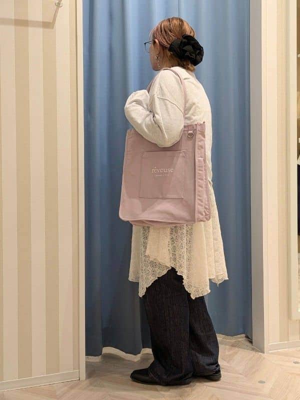 グレー系のスウェット、ホワイト系のチュニック、ブルー系のデニムパンツを着用したレディースの冬コーディネートの2枚目の写真