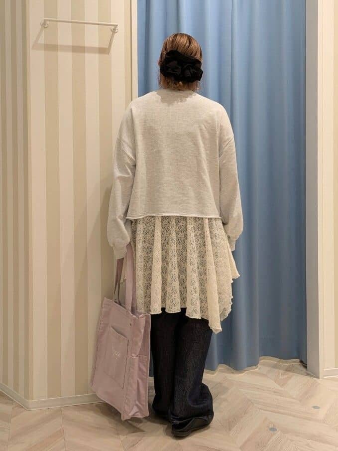 グレー系のスウェット、ホワイト系のチュニック、ブルー系のデニムパンツを着用したレディースの冬コーディネートの3枚目の写真