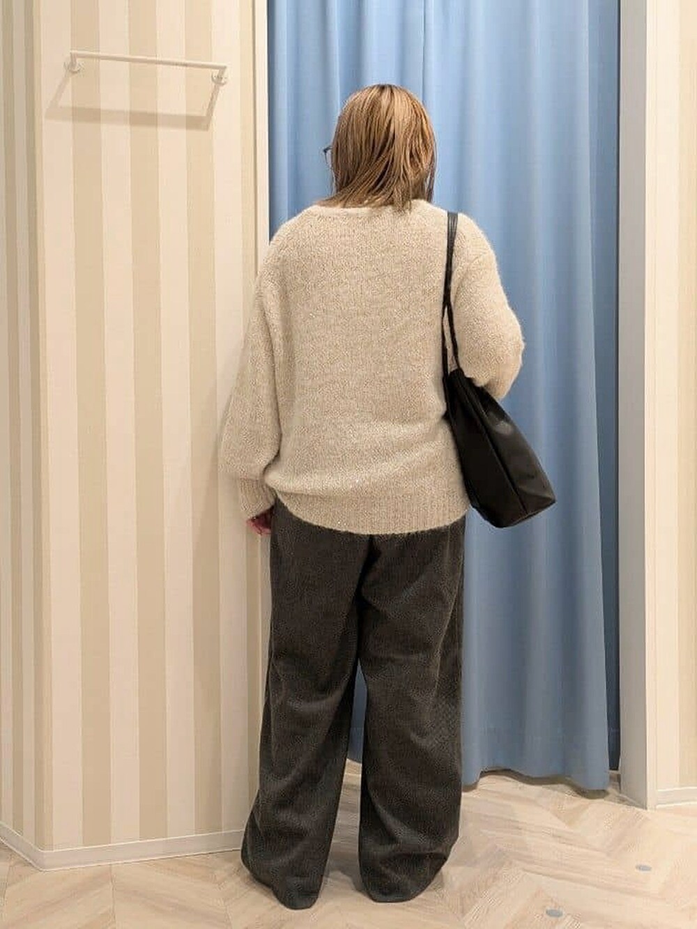 ホワイト系のニット/セーター、ブラック系のその他パンツ、ブラック系のトートバッグを着用したレディースの冬コーディネートの3枚目の写真