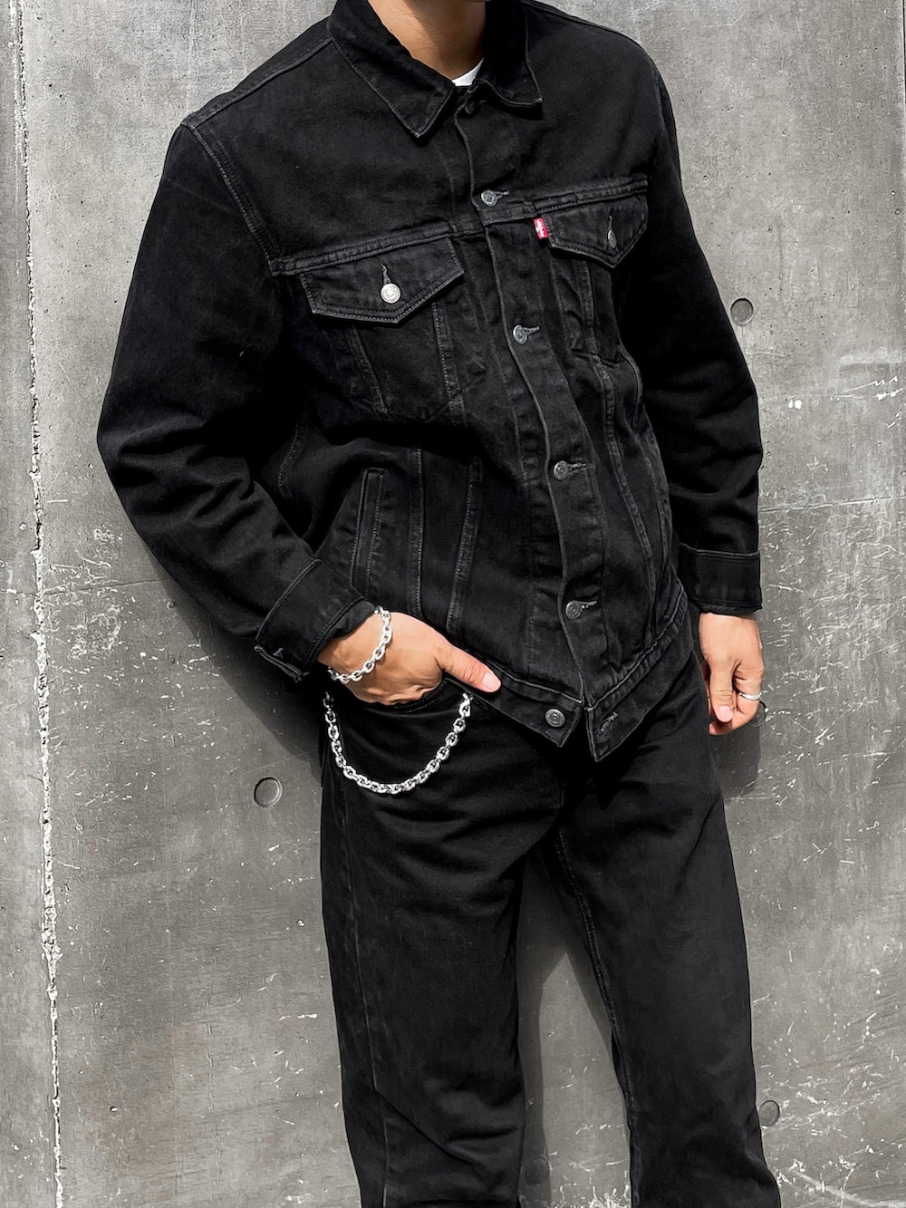 ブラック系のデニムジャケット、ブラック系のデニムパンツ、ブラック系のブーツを着用したメンズの秋コーディネートの3枚目の写真