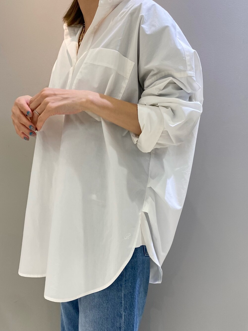 ホワイト系のシャツ/ブラウス、ブルー系のデニムパンツ、ブラック系のショルダーバッグを着用したレディースの冬コーディネートの4枚目の写真