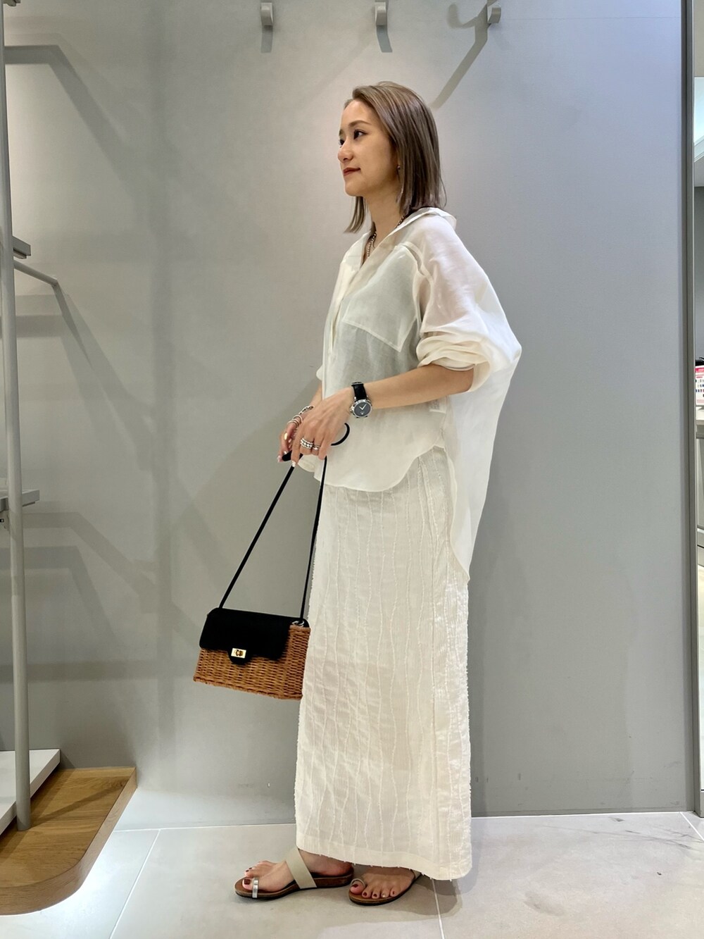 ホワイト系のシャツ/ブラウス、ホワイト系のスカート、ブラック系のショルダーバッグを着用したレディースの春コーディネートの3枚目の写真