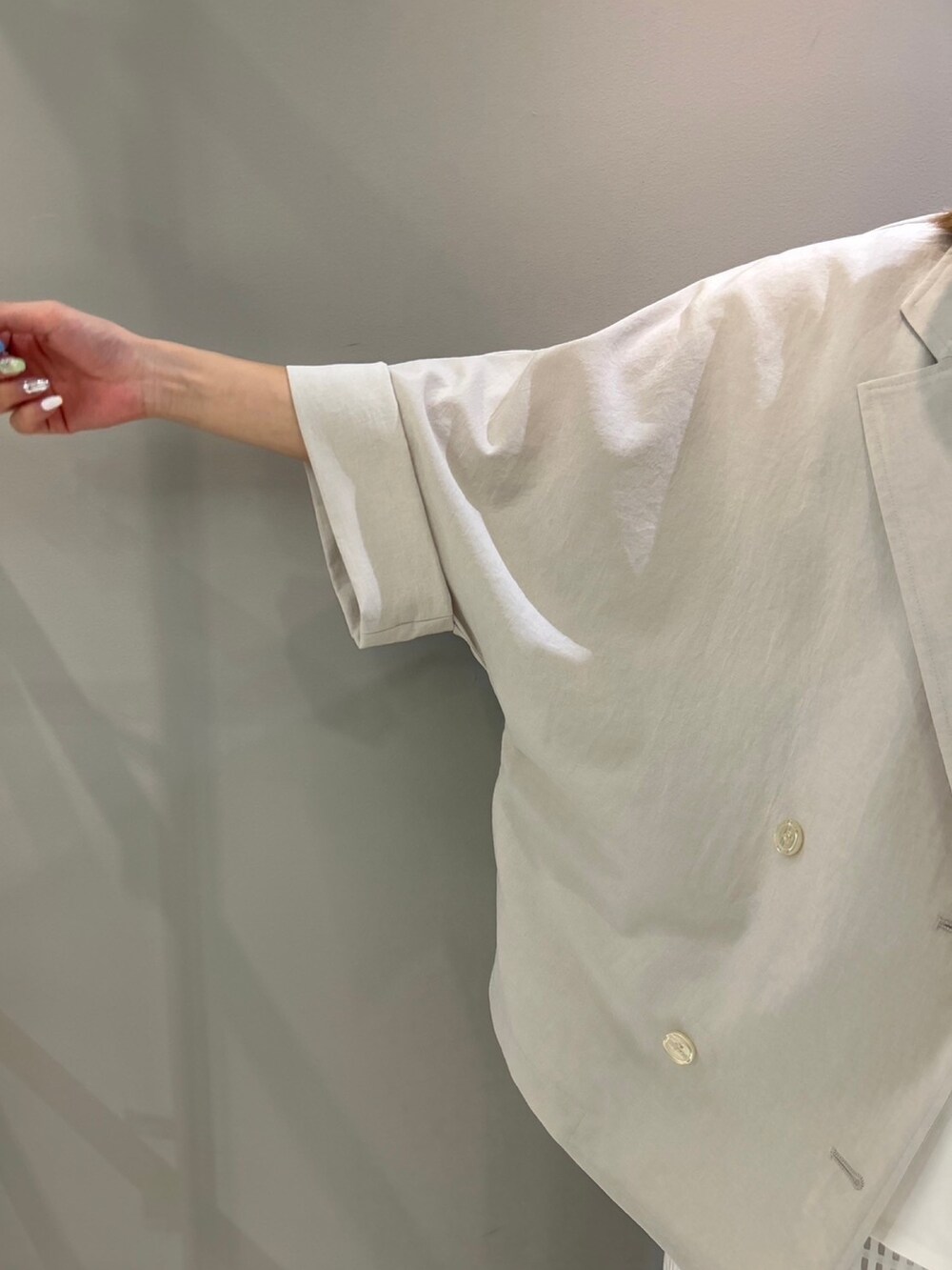 ベージュ系のテーラードジャケット、ホワイト系のスカート、ホワイト系のTシャツ/カットソーを着用したレディースの夏コーディネートの7枚目の写真