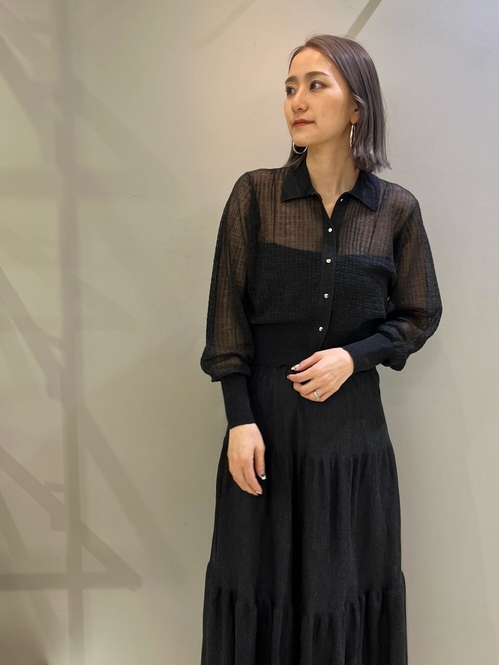 グレー系のカーディガン/ボレロ、ブラック系のショルダーバッグ、グレー系のスカートを着用したレディースの春コーディネートの2枚目の写真