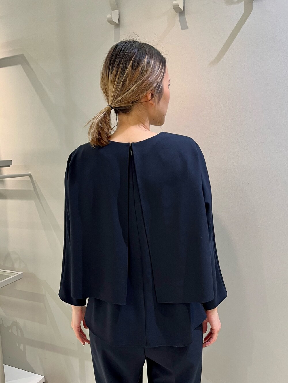 ブルー系のパンツドレス、ベージュ系のショルダーバッグを着用したレディースの冬コーディネートの3枚目の写真