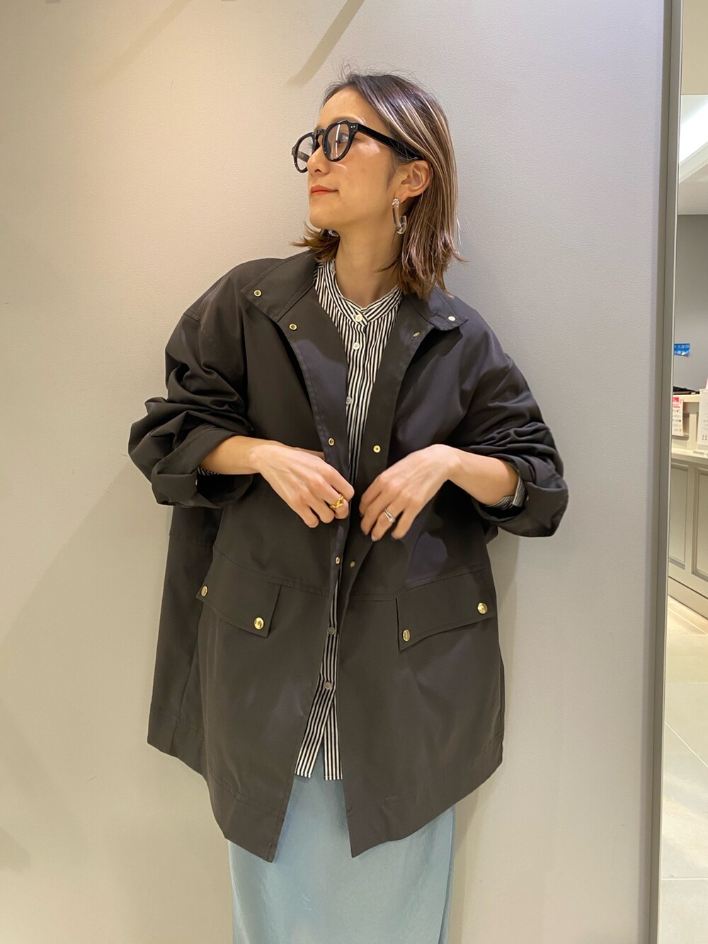 グリーン系のスカート、グレー系のブルゾン、ブラック系のシャツ/ブラウスを着用したレディースの冬コーディネートの3枚目の写真