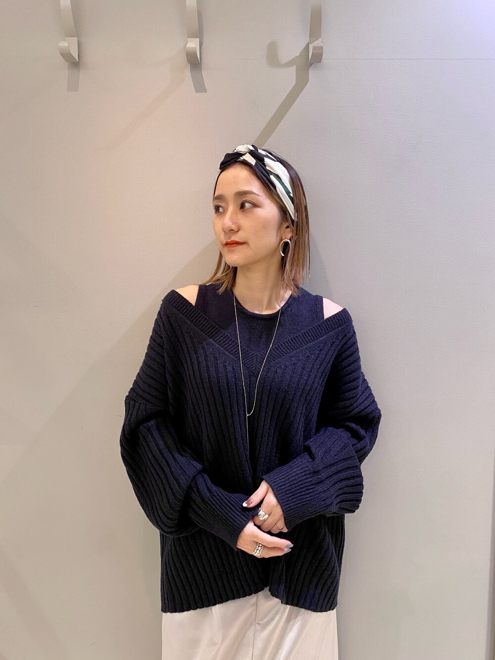 ブルー系のニット/セーター、ブラック系のサンダル、ブラック系のショルダーバッグを着用したレディースの冬コーディネートの3枚目の写真