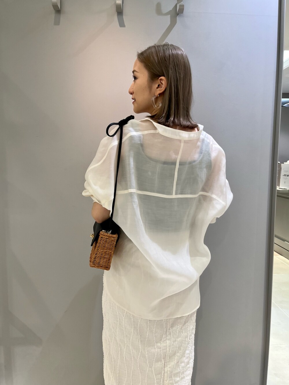 ホワイト系のシャツ/ブラウス、ホワイト系のスカート、ブラック系のショルダーバッグを着用したレディースの春コーディネートの5枚目の写真