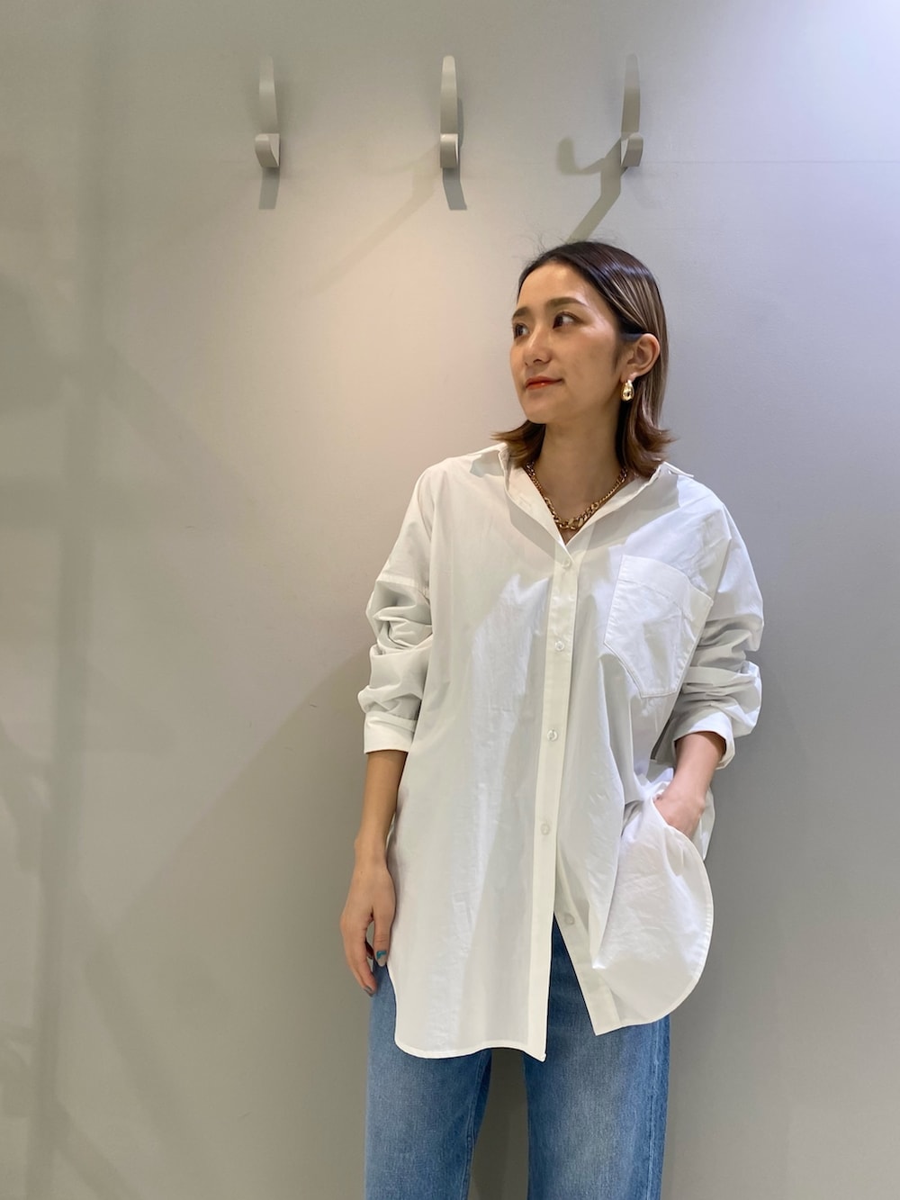 ホワイト系のシャツ/ブラウス、ブルー系のデニムパンツ、ブラック系のショルダーバッグを着用したレディースの冬コーディネートの2枚目の写真