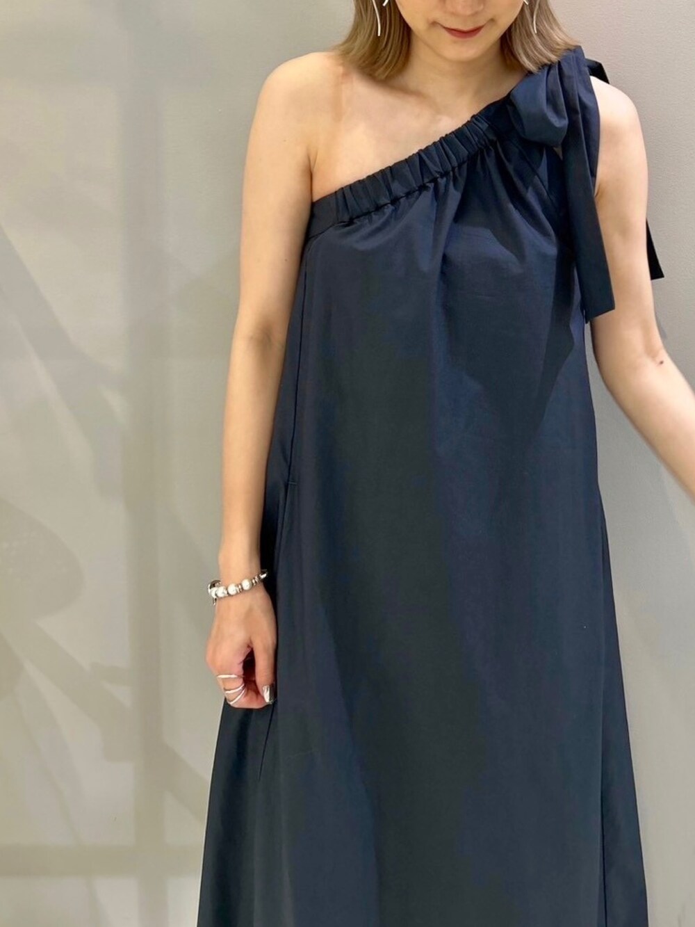 グレー系のワンピース、ブラック系のハットを着用したレディースの春コーディネートの3枚目の写真