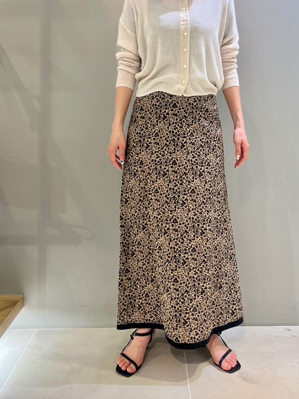 グレー系のカーディガン/ボレロ、ブラック系のショルダーバッグ、ブラック系のサンダルを着用したレディースの春コーディネートの3枚目の写真