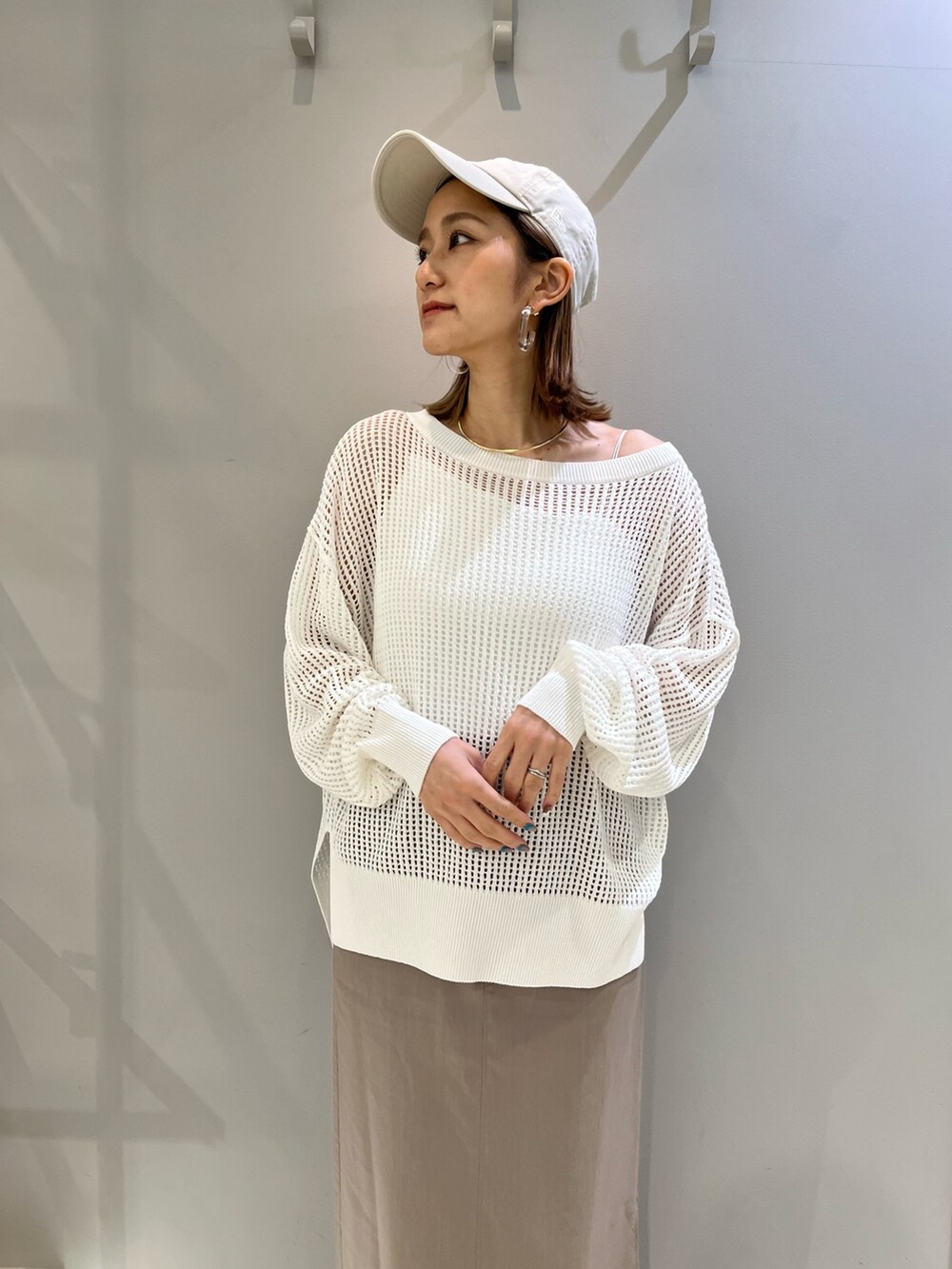 ホワイト系のスニーカー、ホワイト系のショルダーバッグ、グレー系のスカートを着用したレディースの春コーディネートの2枚目の写真