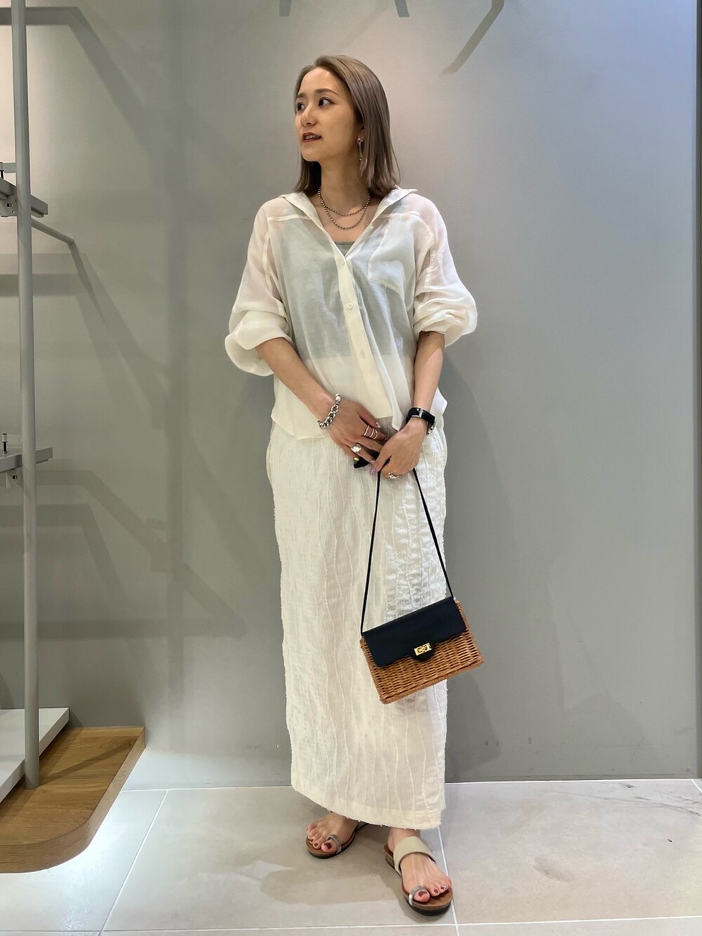 ホワイト系のシャツ/ブラウス、ホワイト系のスカート、ブラック系のショルダーバッグを着用したレディースの春コーディネートの2枚目の写真