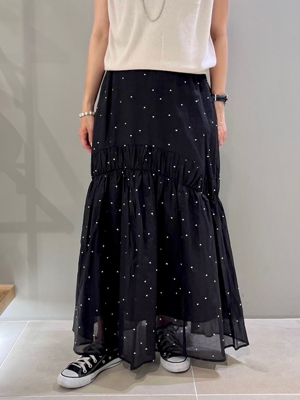 グレー系のニット/セーター、ブラック系のスカート、ブラウン系のショルダーバッグを着用したレディースの夏コーディネートの5枚目の写真