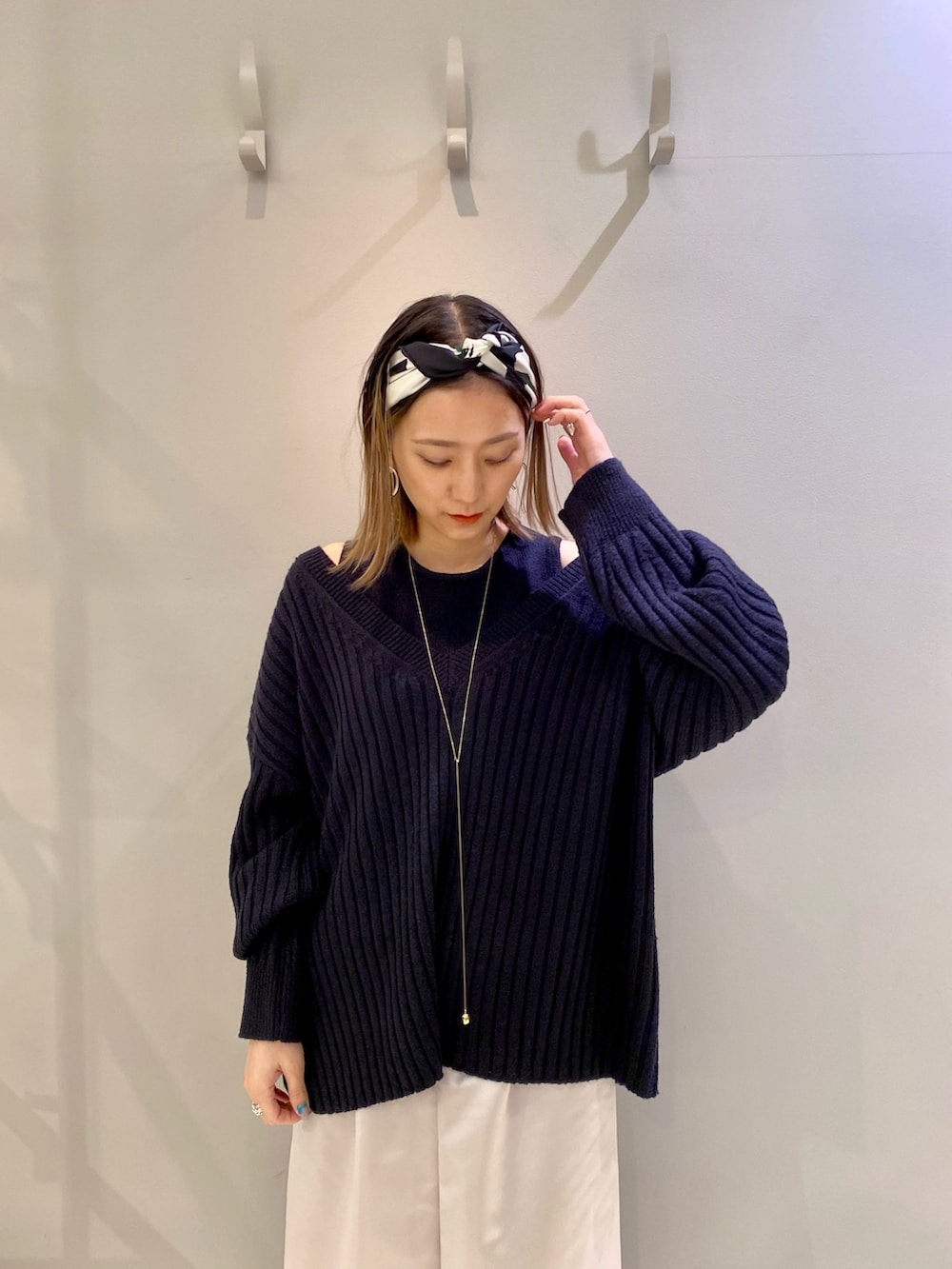 ブルー系のニット/セーター、ブラック系のサンダル、ブラック系のショルダーバッグを着用したレディースの冬コーディネートの2枚目の写真