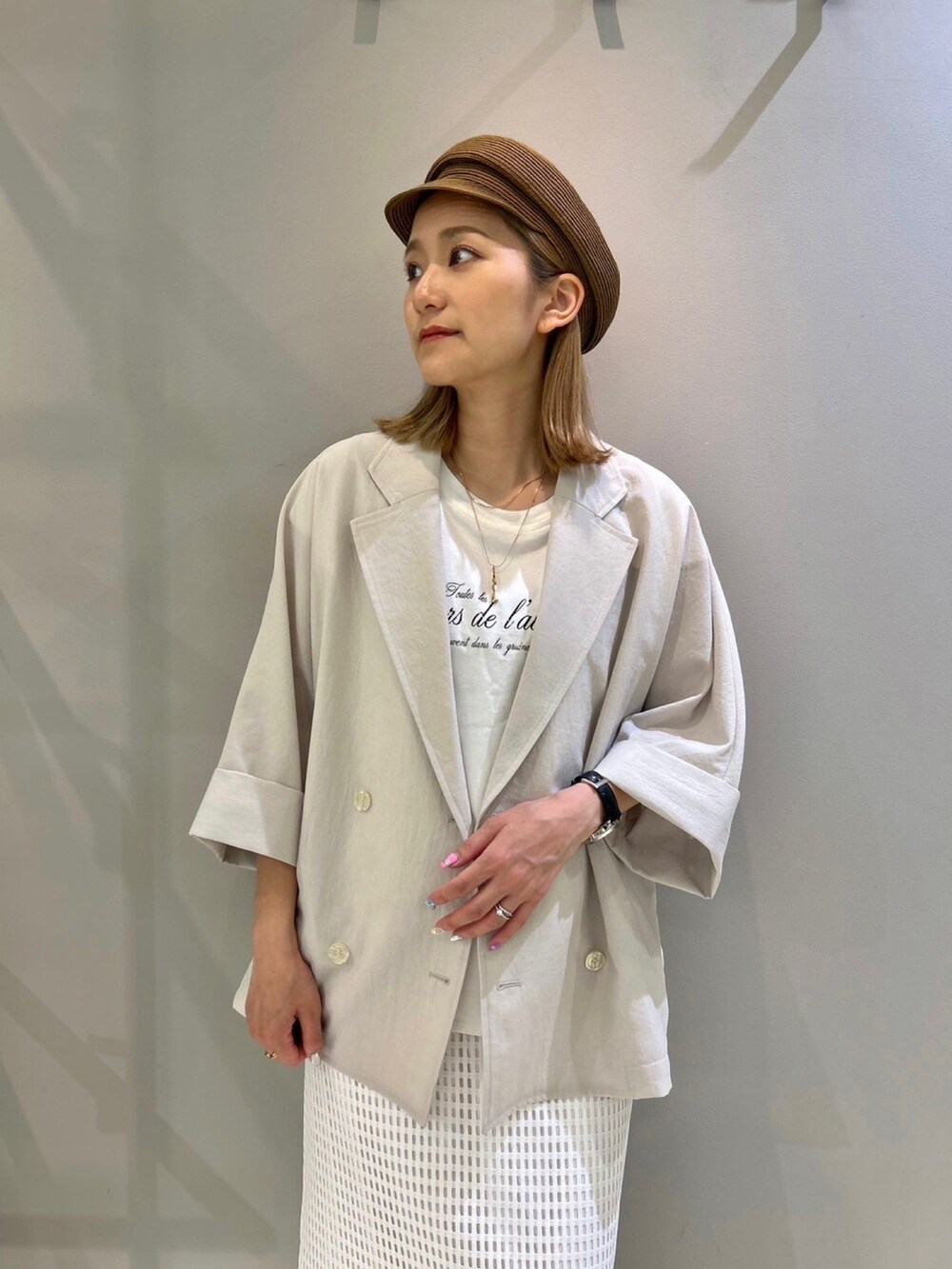 ベージュ系のテーラードジャケット、ホワイト系のスカート、ホワイト系のTシャツ/カットソーを着用したレディースの夏コーディネートの4枚目の写真