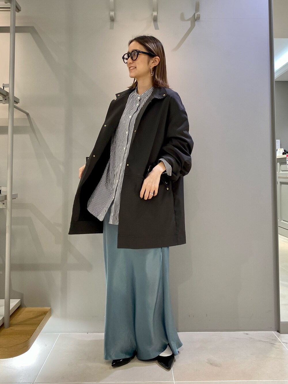 グリーン系のスカート、グレー系のブルゾン、ブラック系のシャツ/ブラウスを着用したレディースの冬コーディネートの2枚目の写真