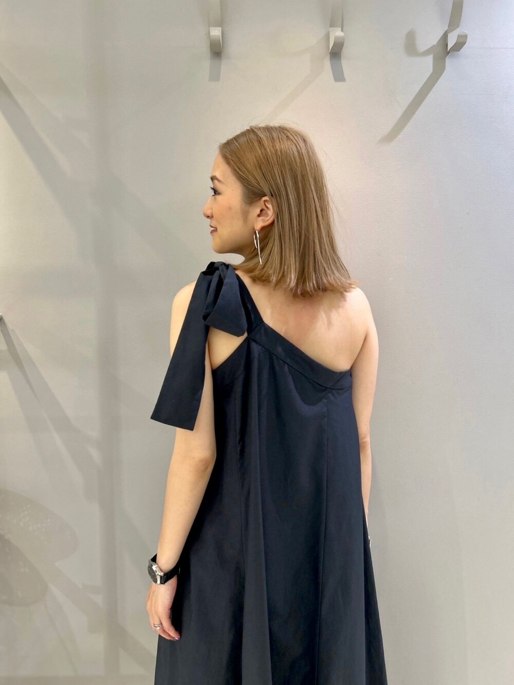 グレー系のワンピース、ブラック系のハットを着用したレディースの春コーディネートの4枚目の写真