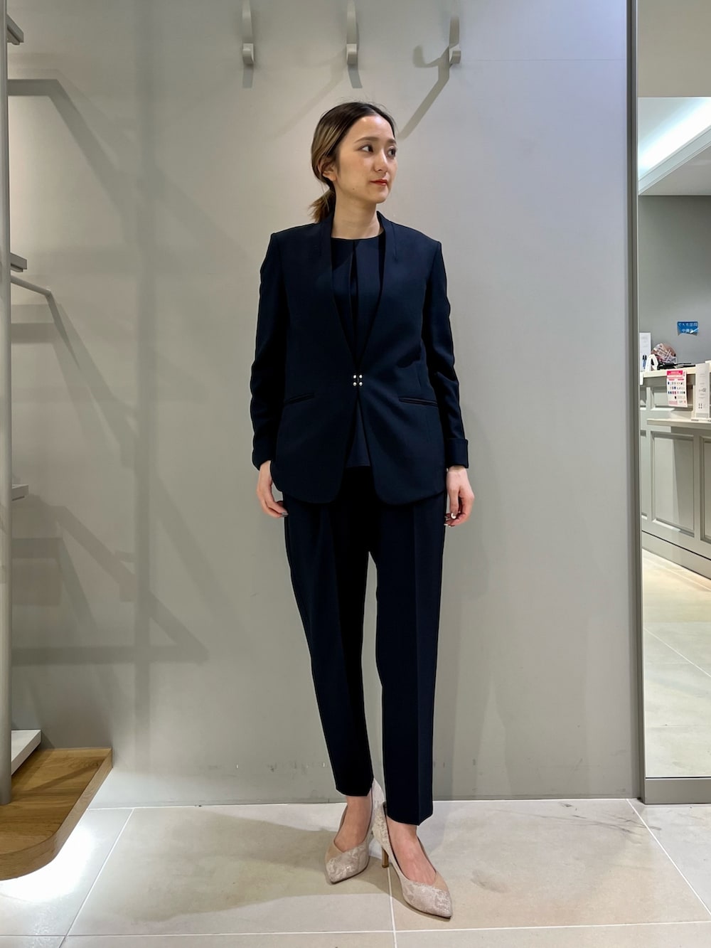 ブルー系のパンツドレス、ベージュ系のショルダーバッグを着用したレディースの冬コーディネートの2枚目の写真