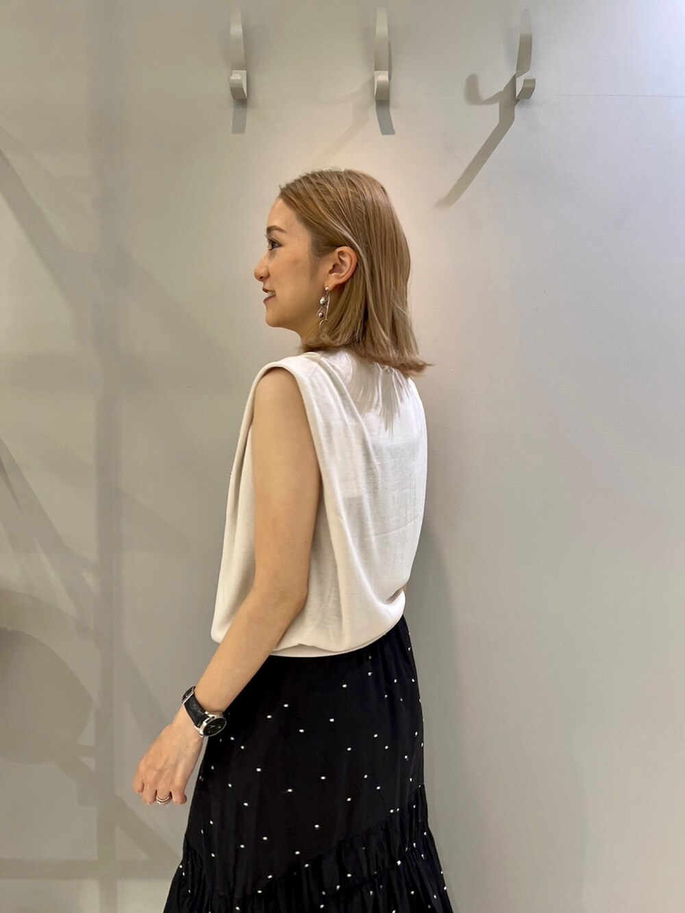 グレー系のニット/セーター、ブラック系のスカート、ブラウン系のショルダーバッグを着用したレディースの夏コーディネートの4枚目の写真