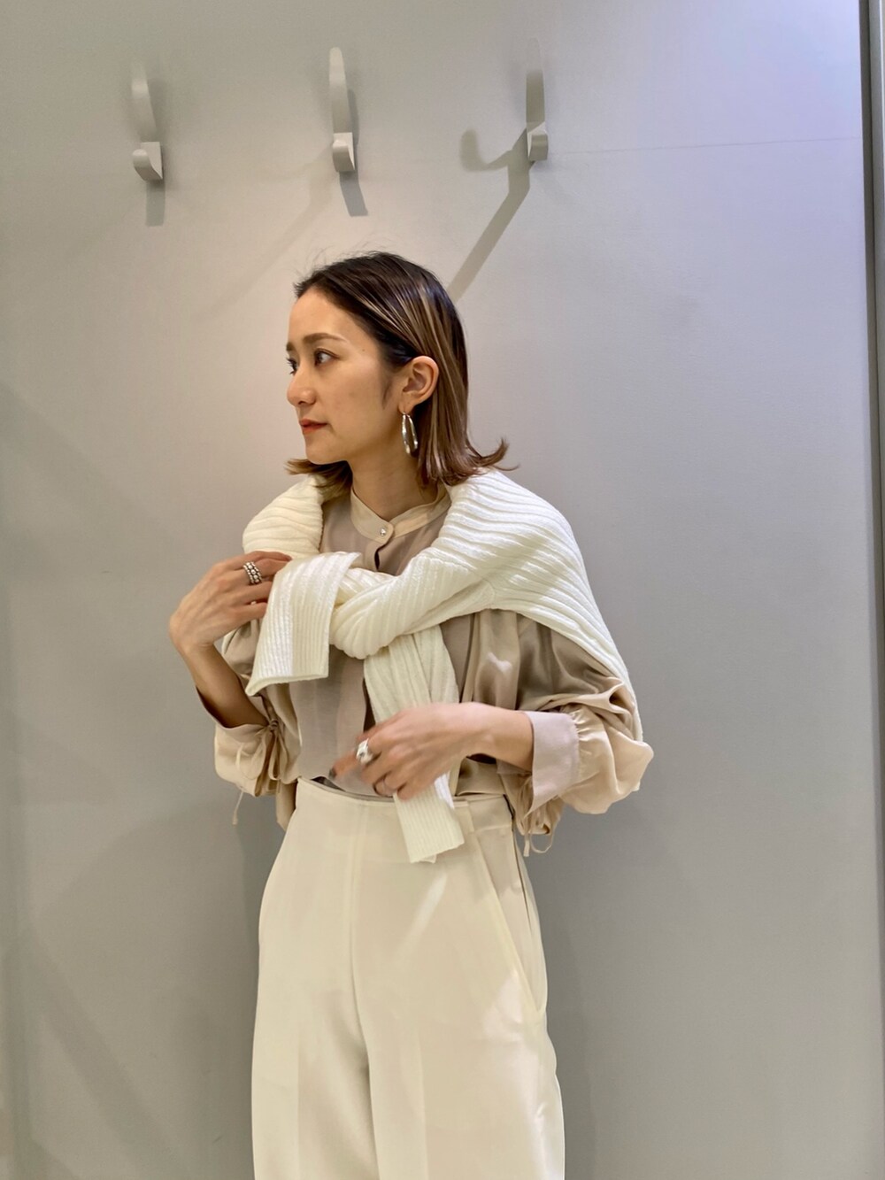 ホワイト系のその他パンツ、ベージュ系のシャツ/ブラウス、ホワイト系のニット/セーターを着用したレディースの冬コーディネートの3枚目の写真