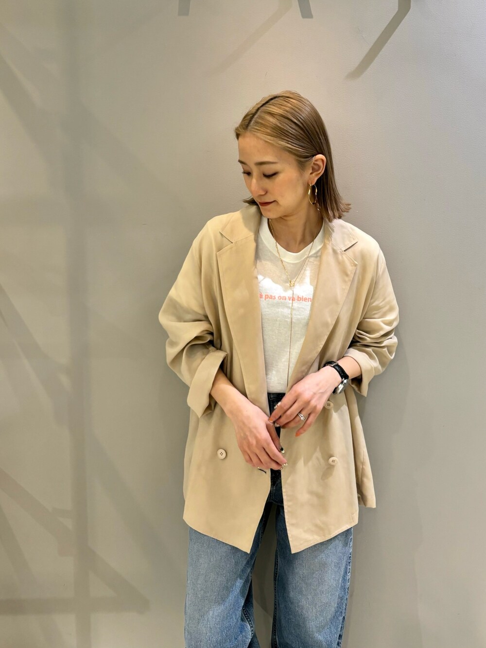 ピンク系のTシャツ/カットソー、ベージュ系のテーラードジャケット、ブルー系のデニムパンツを着用したレディースの春コーディネートの2枚目の写真